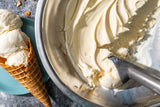 Scooping out some vanilla ice cream from a silver bowl